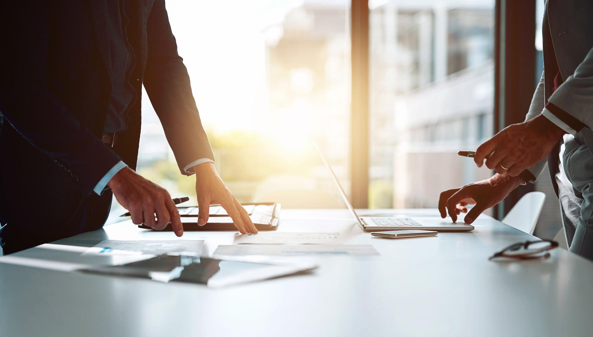 Planning, strategy and hands of business people in office with paperwork, laptop and negotiation. Meeting, ideas and teamwork in conference room for growth, development and project management at desk